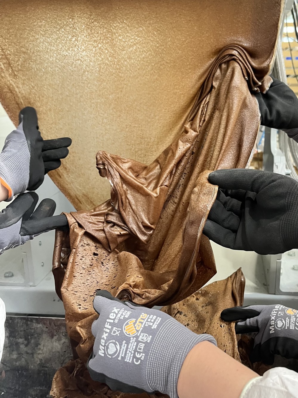 Hände, die ein Material Formen. Mehlwurmkot erstmals gebunden mit einem Bio PLA. Ein Workshop von Yana Zschiedrich zusammen mit dem Forschungscluster MERGE. Teilnehmende: Brigita Kasperaite, Corinna Wolff, Taisiia Kravchenko und Olena Melnyk.