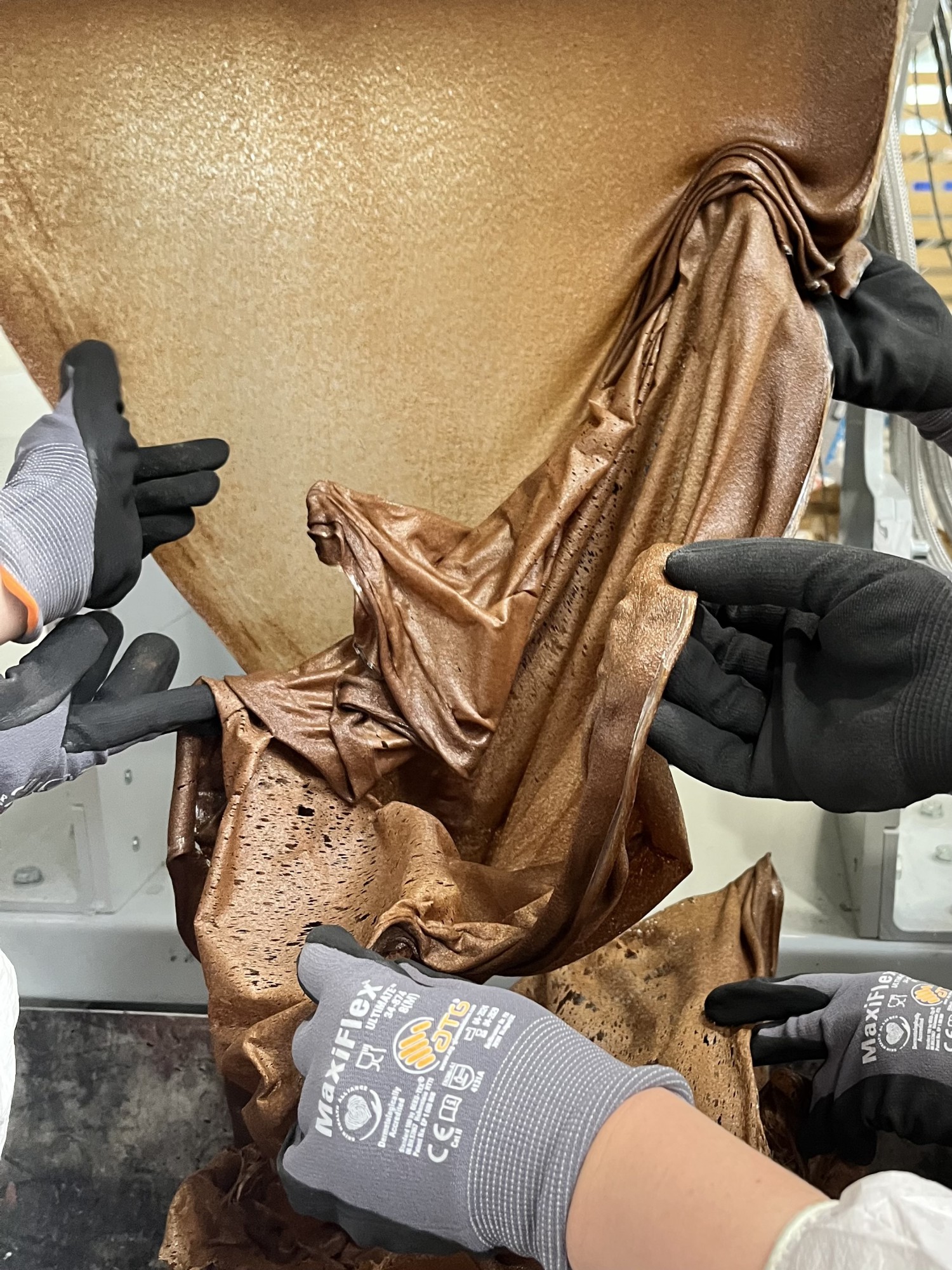 Hände, die ein Material Formen. Mehlwurmkot erstmals gebunden mit einem Bio PLA. Ein Workshop von Yana Zschiedrich zusammen mit dem Forschungscluster MERGE. Teilnehmende: Brigita Kasperaite, Corinna Wolff, Taisiia Kravchenko und Olena Melnyk.