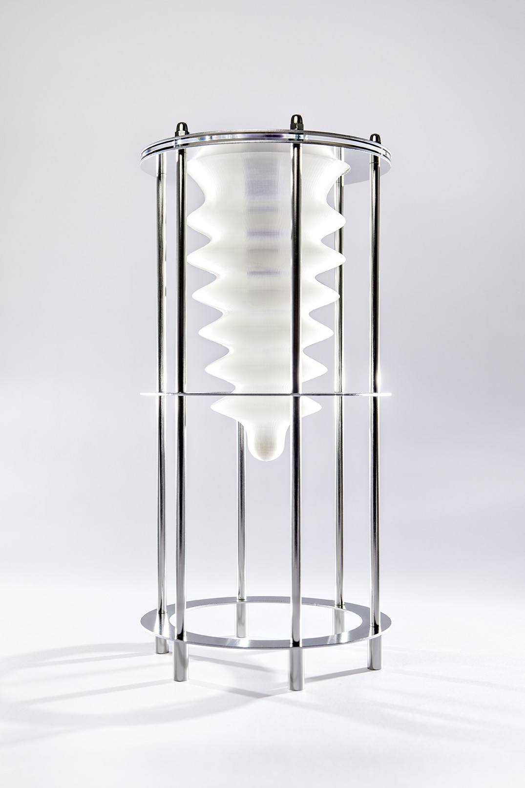 The object depicts a kind of worm body, clamped in an experimental setup. The mealworm becomes a machine that digests humanity's waste.